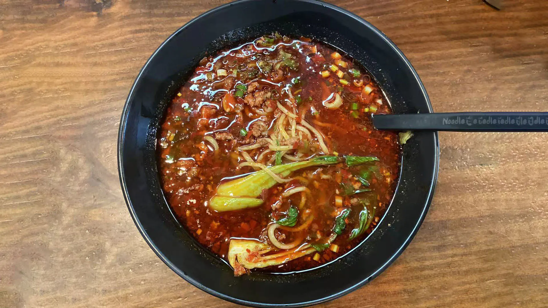 Rich bold hot and spicy savory noodle soup with fresh veggies at Noodle Man，a Chinese Restaurant in Virginia Beach