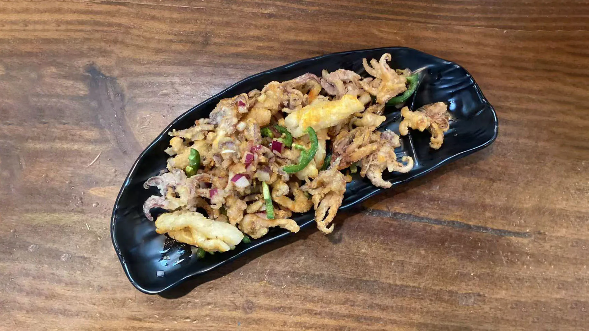 Tender salt and spicy squid stir-fried with fresh green onions at Noodle Man，a Chinese Restaurant in Virginia Beach