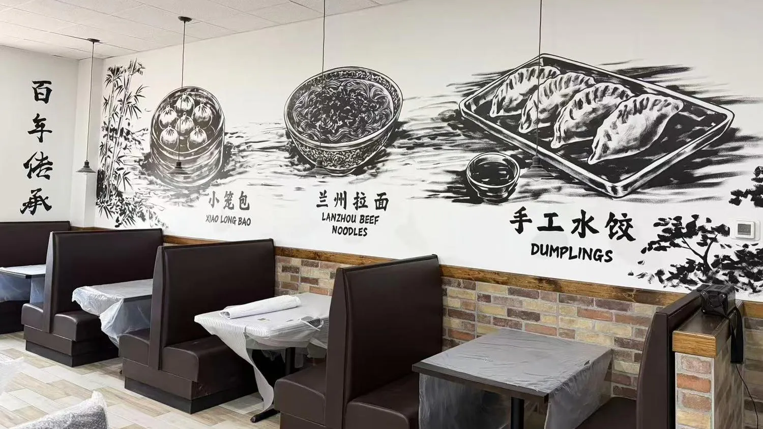 Chinese food mural with calligraphy beside restaurant booth seats at Noodle Man，a Chinese Restaurant in Virginia Beach